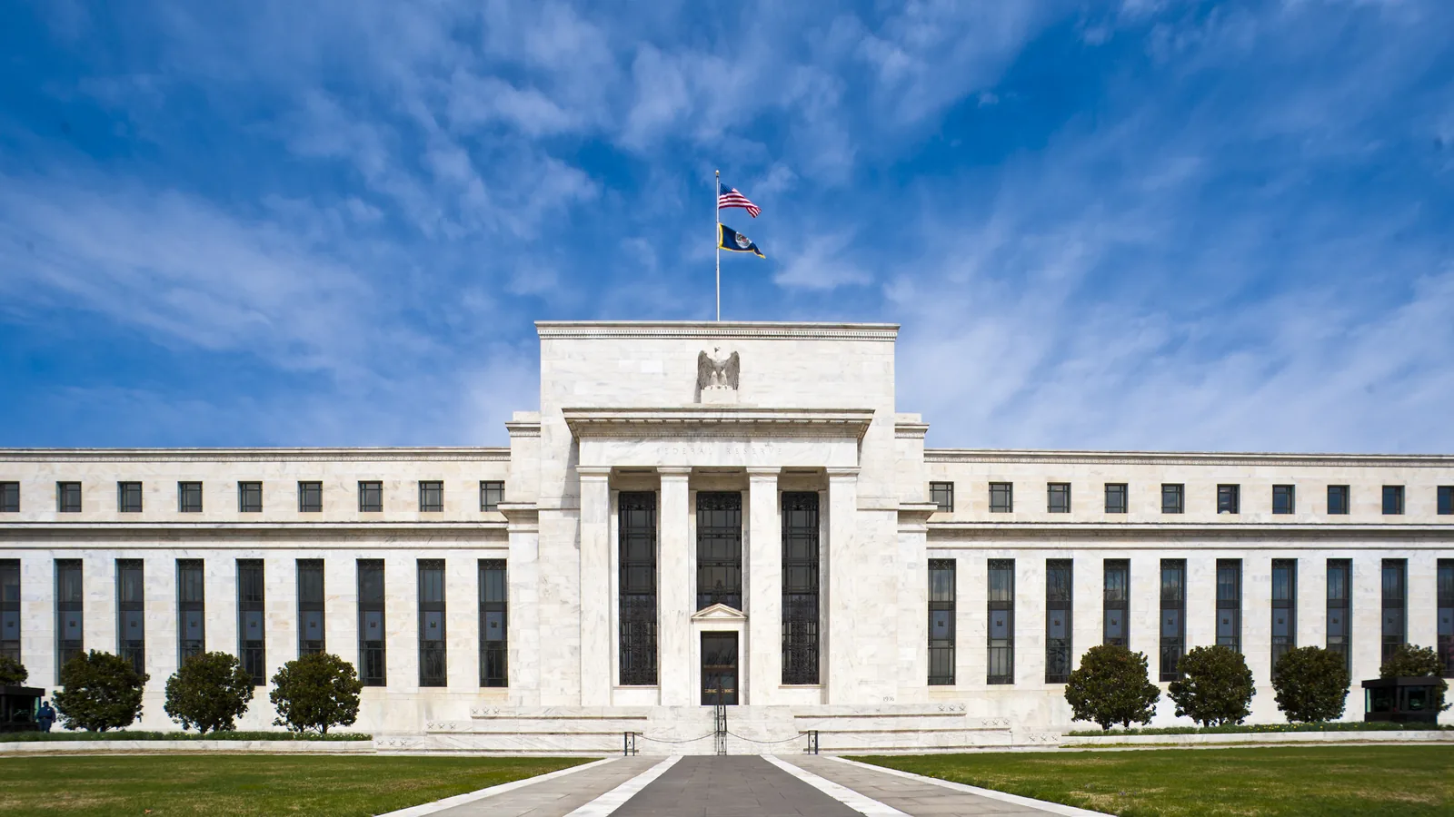 White marble front of the Federal Reserve's Eccles Building in Washington under a blue sky