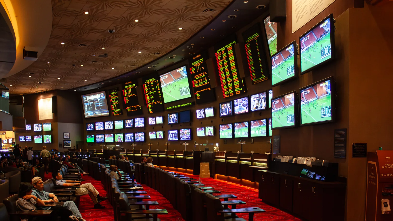 Rows of screens showing games and odds above the seats of the MGM Grand sports book in Las Vegas
