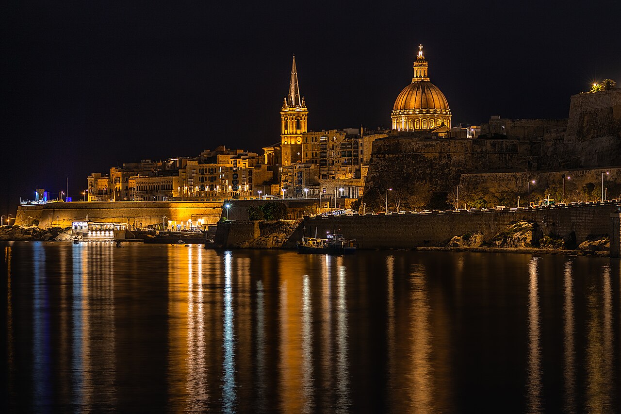 Valletta’s illuminated skyline at night, reflected in the sea