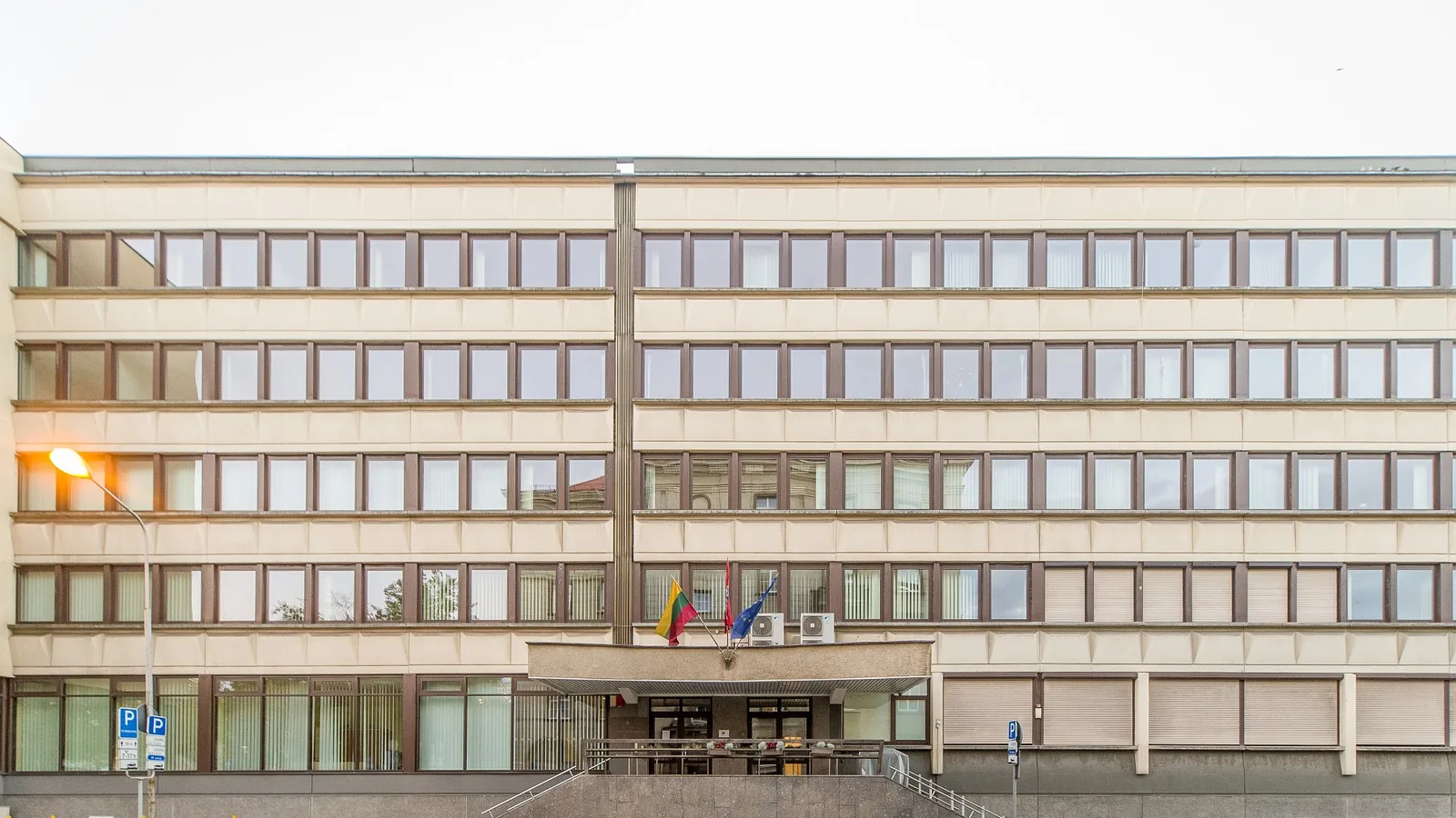 Front of the Lithuanian Ministry of Finance in Vilnius, a long office building with flags at the entrance