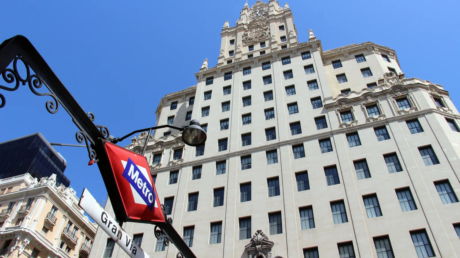 The Telefónica building in Madrid seen from the street, behind a Gran Vía metro sign