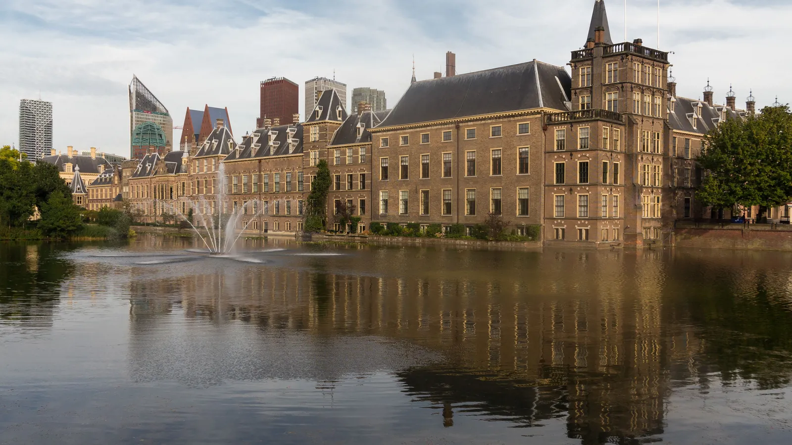 The Binnenhof's brick buildings and towers reflected in the Hofvijver pond in The Hague