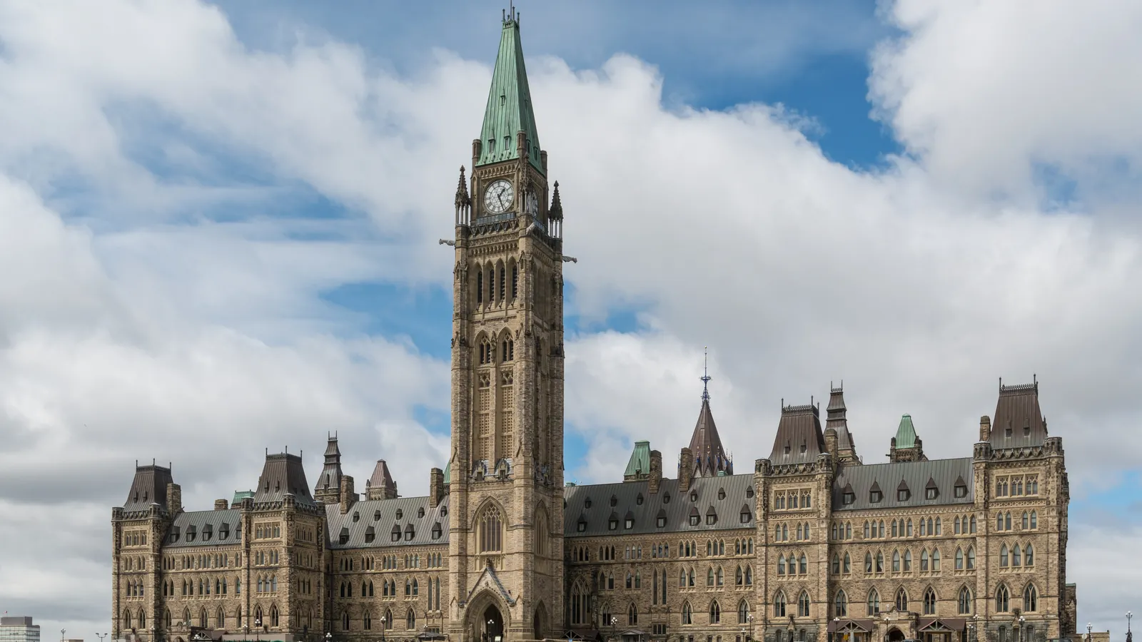 The Gothic Revival Centre Block of Canada's Parliament in Ottawa, with the clock of the Peace Tower, under a cloudy sky