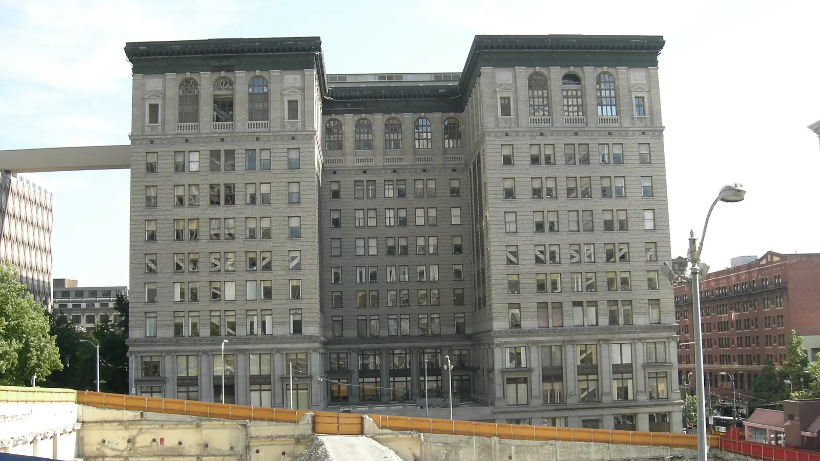 The grey stone King County Courthouse in Seattle, seen across a fenced construction site in 2007